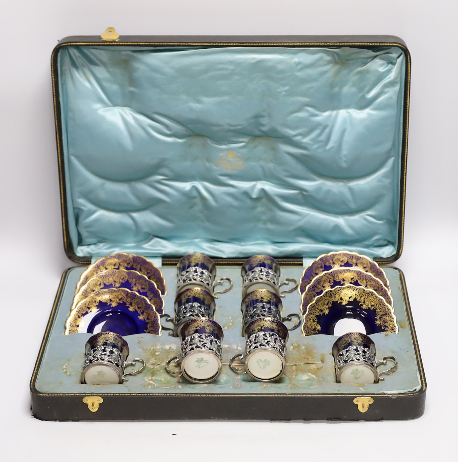 A set of eight Aynsley porcelain coffee cans and saucers, the cans with silver holders, William Hutton & Sons, London, 1905, with fitted case for six (no spoons)